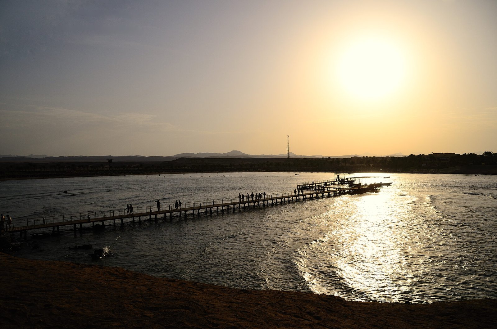 jetty with people at sunset