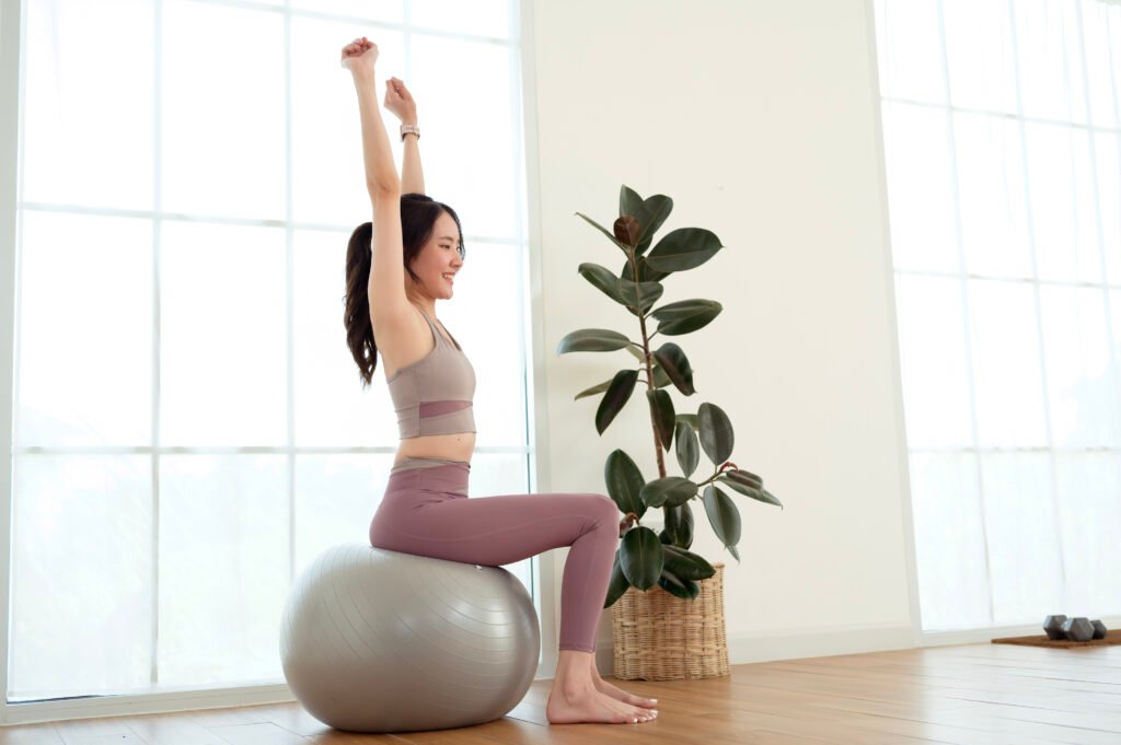 young asian woman exercising with fitness ball