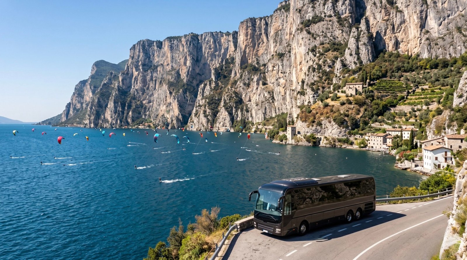 Dozens of kitesurfers riding on the deep blue water of Lake Garda with towering alpine cliffs in the background